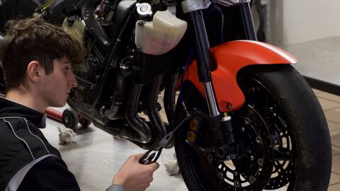 Prise de pression des pneus d'une moto par des techniciens de la compétition moto sur le circuit de Nogaro